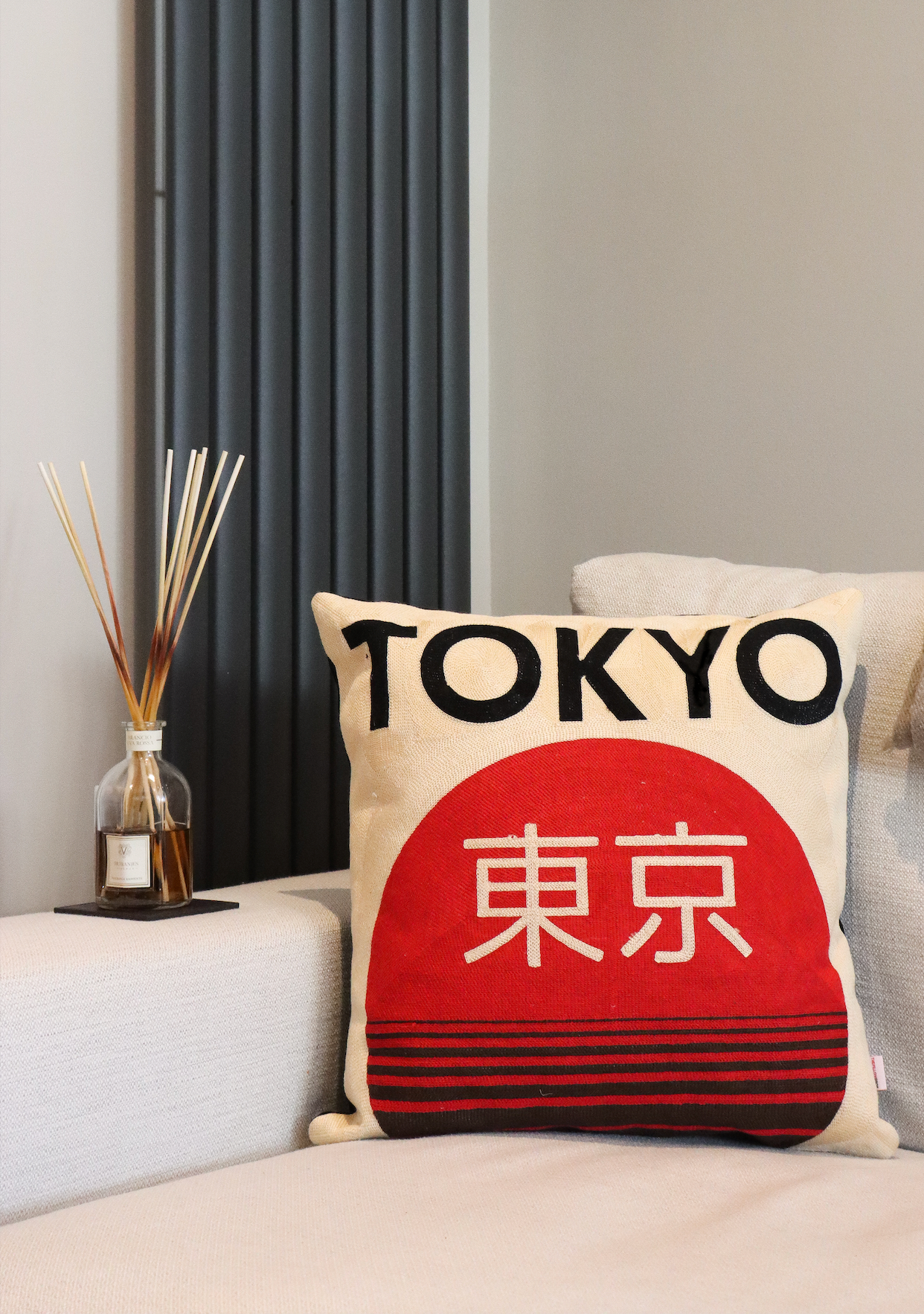 Tokyo needlepoint cushion styled on modern grey sofa – luxury red and white embroidered cushion cover handmade by Opulent Co, perfect for contemporary living room décor in the UK.